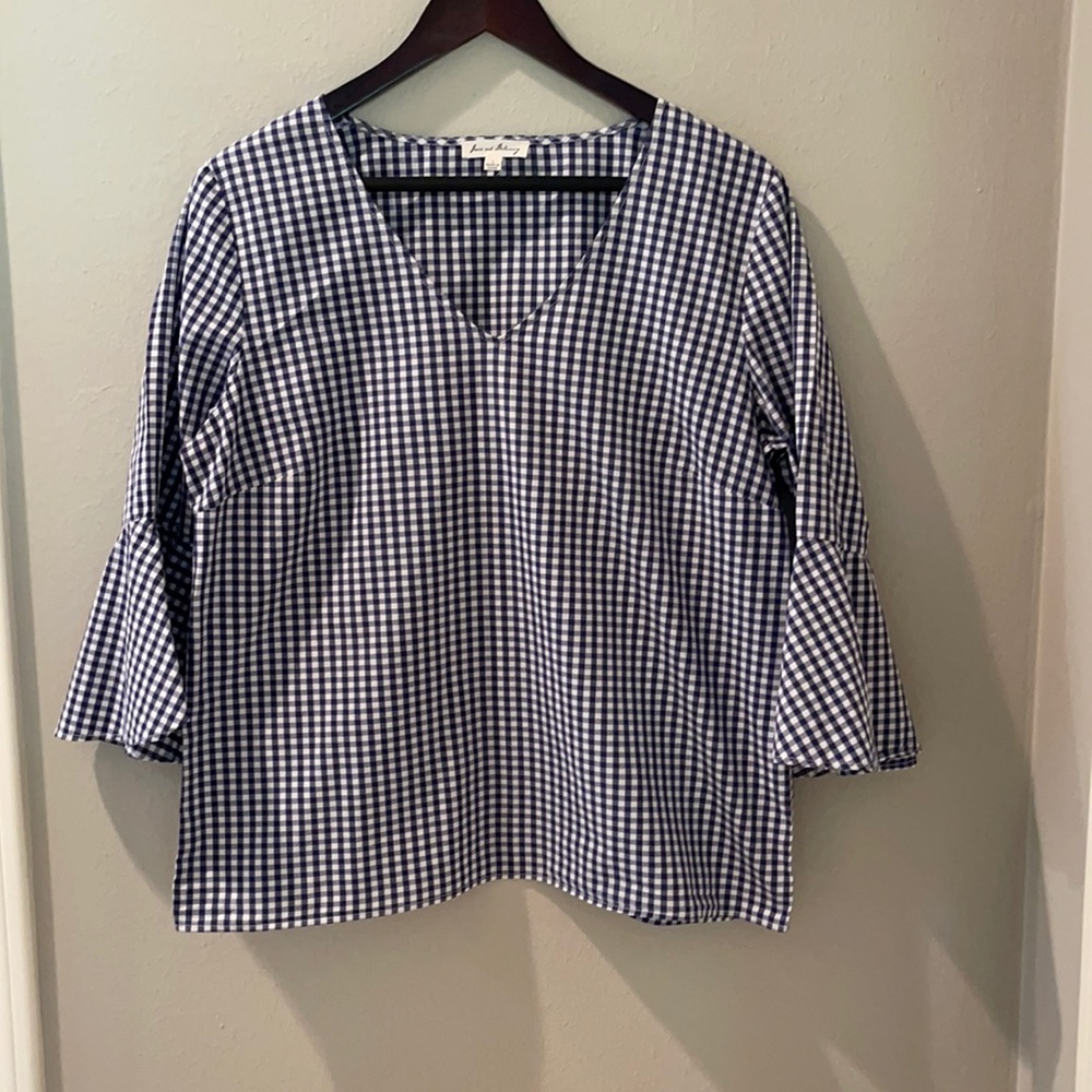 Blue and white checked top with ruffled sleeves.